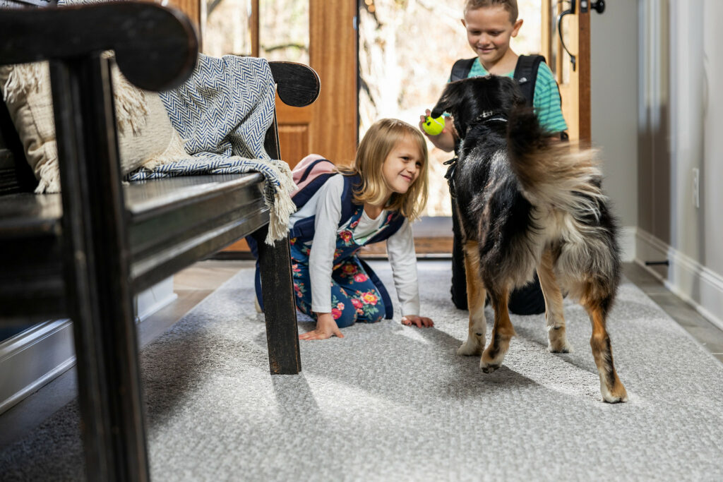 Kids playing with dog on carpet floors | Dalton Flooring Outlet